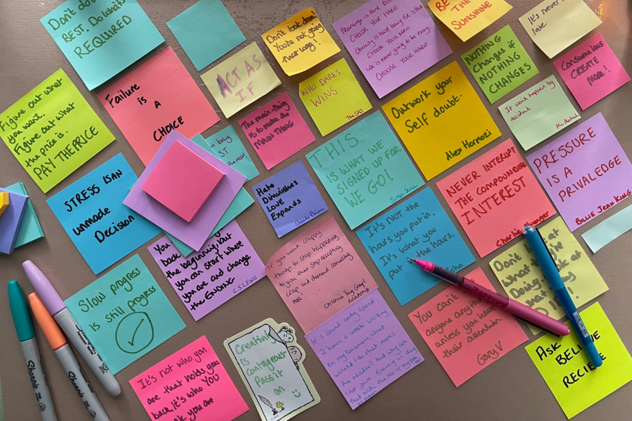 A desk full of post-it notes with quotes on them 